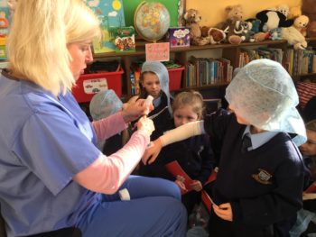 Nurse Joanne demonstrates how to put on a bandage.